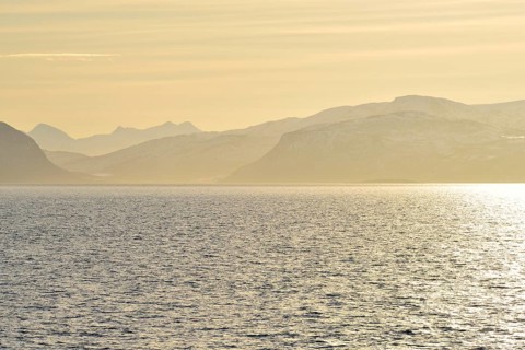 Glistening water and the mountains of Hinnoya in the yellow morning light