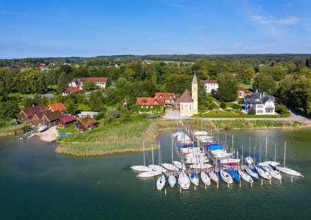 Boat landing stage in the Lake Ammer and church St. Alban
