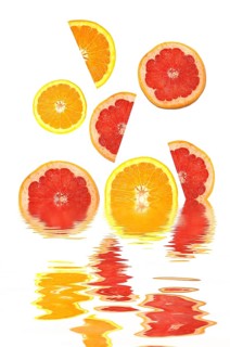 Orange slices and grapefruit slices with reflections in water