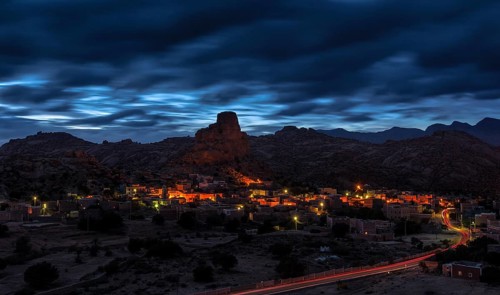 Small village of Aguard Oudad with brightly painted houses in front of the rock Chapeau Napoleon