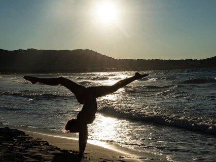 Young woman doing gymnastics on the beach