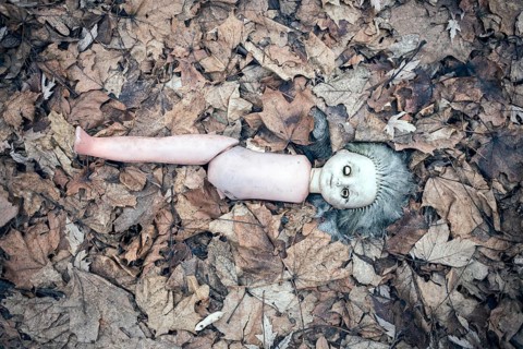 Broken doll lying in the front garden of an abandoned kindergarten