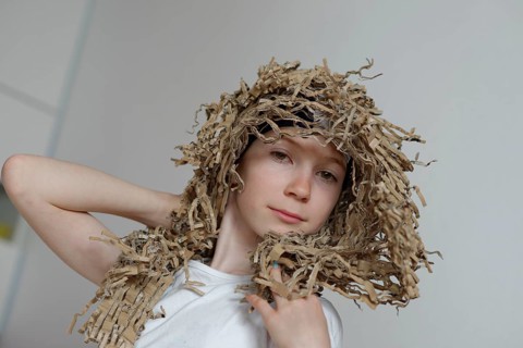 Girl wearing a wig made from cardboard packaging