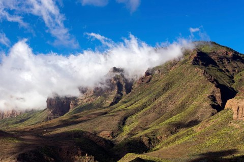 Wispy clouds over a mountain ridge
