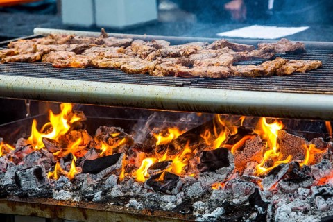 Steaks on a charcoal grill with flames