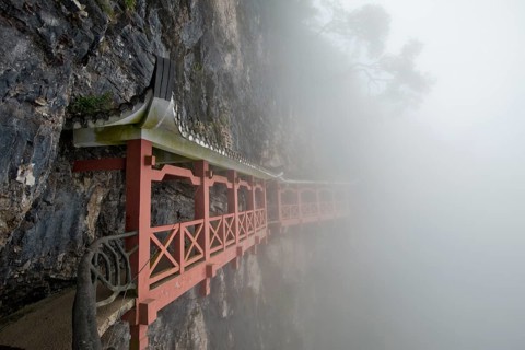 Covered hiking trail on a cliff in fog