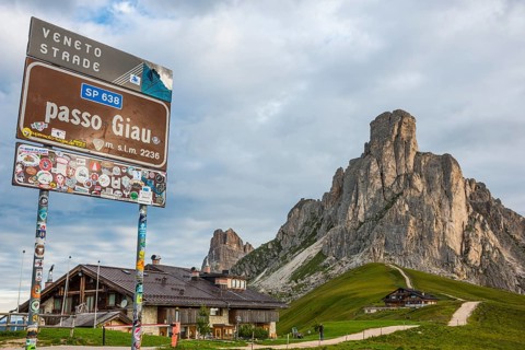 Signboard and hut at Giau Pass with Gusela mountain at the back