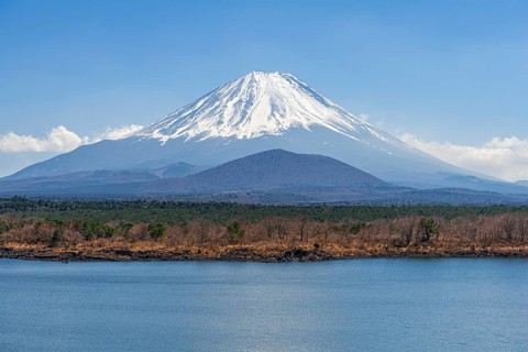 View over a lake to the volcano Mt Fuji