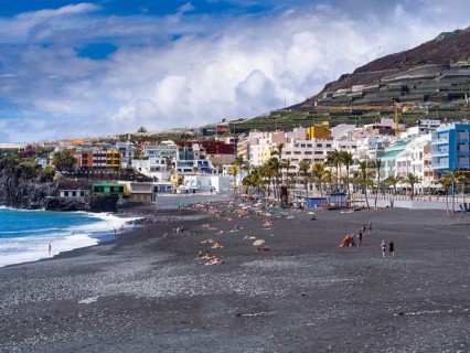 Tourists on the black beach of Puerto Naos