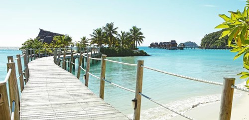 Wooden walkway to overwater bungalows in the sea