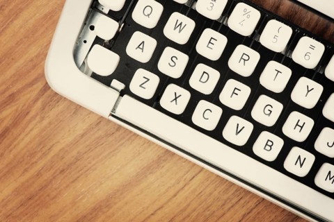 Detail view of the keys on an old fashioned typewriter from the 1970s on a wooden table