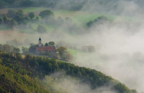 Aerial view of a small church in fog