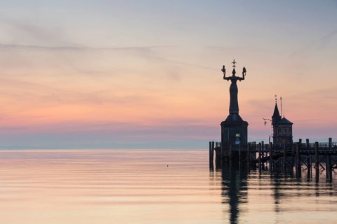 Statue of Imperia at the entrance of the harbour of Konstanz at dawn