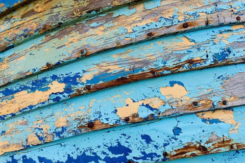 Blue and light blue peeling paint on an old fishing boat