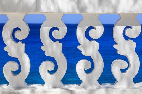White ornate railing with views of the sea