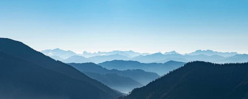 Mountain chains one behind the other in backlight