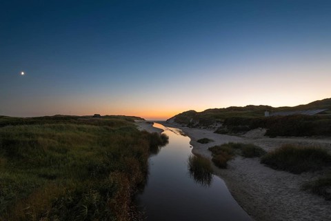 Dune landscape with river Henne Molle A at sunset