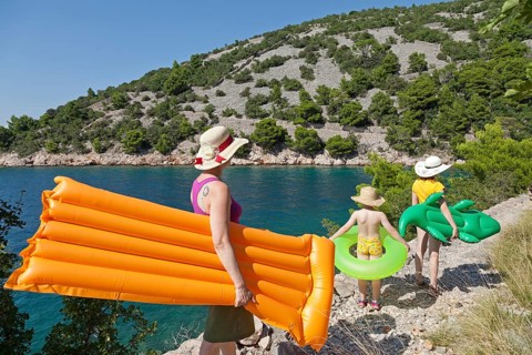 Woman and children on their way to the beach in a bay