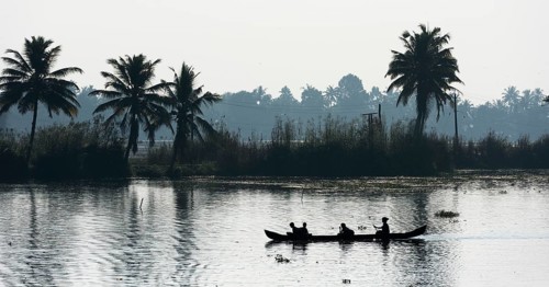Woman taking children to school in a small boat
