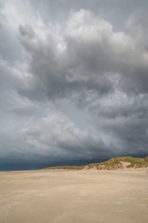 Dramatic storm clouds over beach and dunes