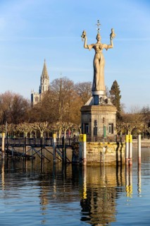 Statue of Imperia at the harbour of Konstanz with Konstanz Cathedral behind