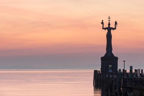 Statue of Imperia at the entrance of the harbour of Konstanz at dawn