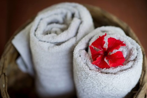 Two rolled white towels in a basket