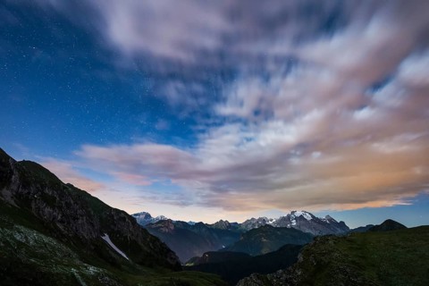Marmolada glacier in a starry night with clouds