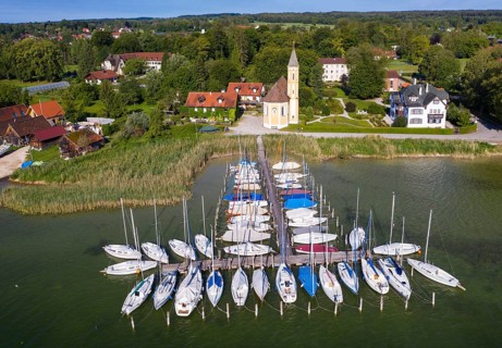 Boat landing stage in the Lake Ammer and church St. Alban