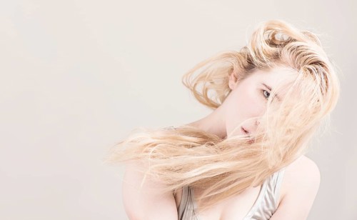 Woman with long blond hair covering her face