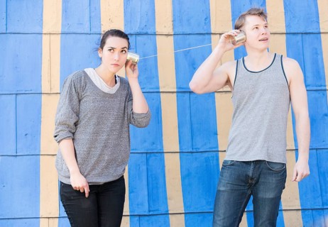 Young woman and young man with a tin can phone