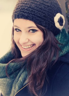 Smiling young woman wearing hat and scarf in winter