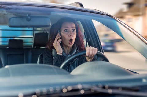 Motorist without a seat belt making a call on a mobile phone