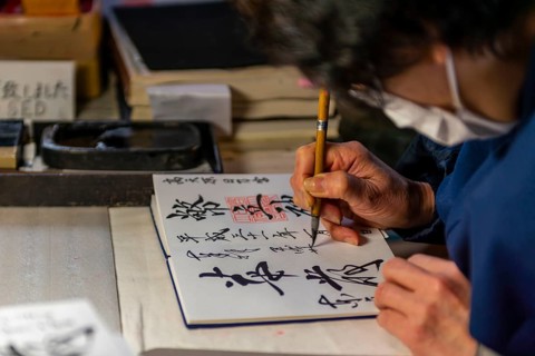 Woman writes Japanese characters
