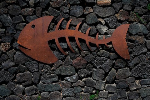 Metal fish on a stone wall