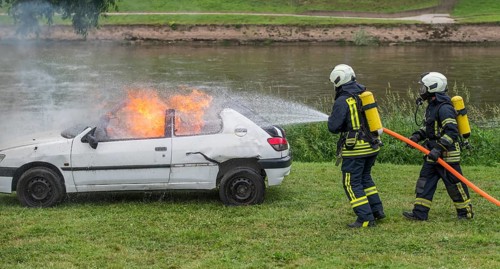 Firefighters extinguish burning car