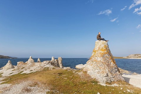 Hiker sitting on one of the legendary dolomite rocks on Porsangerfjorden fjord