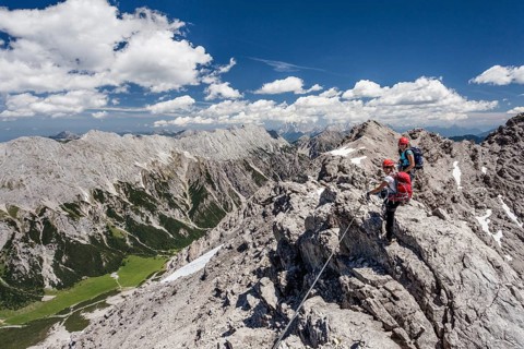 Hikers on the summit ridge during the ascent through the Imster via ferrata on the Maldonkopf in the Lech Valley Alps
