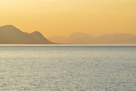 Sunset in the fjord with mountains in the mist