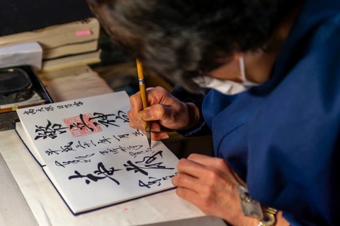 Woman writes Japanese characters