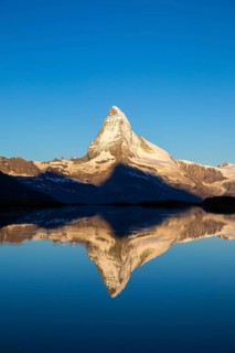 First sunlight on the Matterhorn with reflection in Stellisee lake