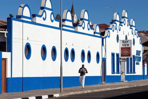 Local man walking in front of a colonial building