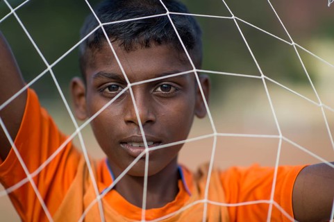 Boy looking through goal net