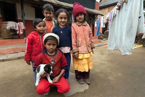 Nepalese children with little dog outside her house