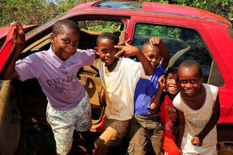 Happy children playing at a car wreck