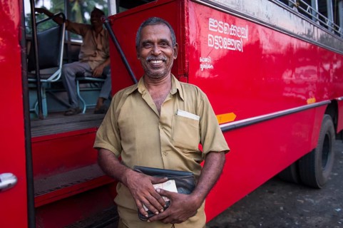 Bus driver in front of a red bus