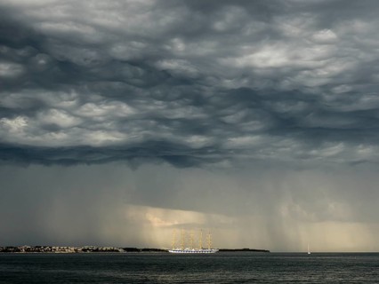 Five-master sailing ship in front of Crveni Vrh in thunderstorm atmosphere seen from Piran