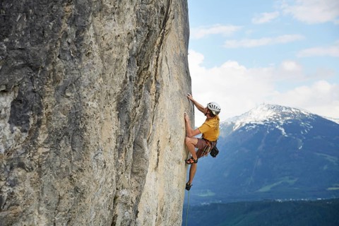 Freeclimber with helmet climbing on a rock face