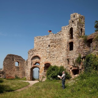 Man with map in front of the Burg Staufen castle ruins