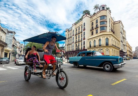 Classic car and bike rickshaw on the road junction at the Hotel Telegrafo